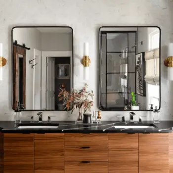 Mirrors over a double sink. The mirrors have a curved edge with black accents.