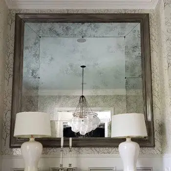 Antiqued mirror above side table in a residential home.